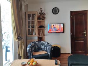 ein Wohnzimmer mit einem Tisch, einem Stuhl und einem TV in der Unterkunft Apartment Ilic in Zlatibor