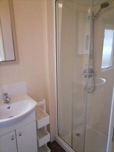 ein Bad mit einer Dusche und einem Waschbecken in der Unterkunft Victory - idyllic holiday home in Hastings in Hastings