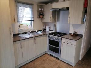 a small kitchen with a stove and a sink at Victory - idyllic holiday home in Hastings in Hastings