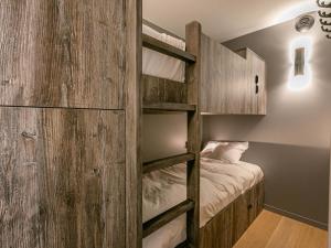a bedroom with a bunk bed and a wooden wall at Appartement Val-d'Isère, 3 pièces, 4 personnes - FR-1-694-326 in Val-d'Isère