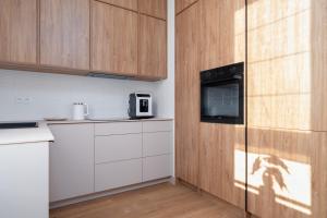 uma cozinha com armários brancos e um micro-ondas em Stylish Beige Apartment with One Bedroom and Parking in Poznań by Renters em Poznań