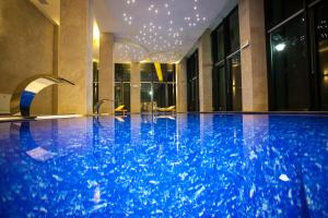 a swimming pool in a hotel with blue water at Malak Regency Hotel in Sarajevo