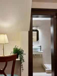 a bathroom with a sink and a table and a chair at Vila Șipot - Casa Arhitecților in Sinaia