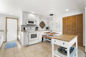 a kitchen with white appliances and a wooden table at Bonfoy Guest House in Colorado Springs