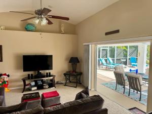 a living room with a couch and a flat screen tv at VILLA PALM ISLAND in Cape Coral