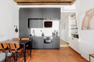 une cuisine avec une table et des chaises noires dans l'établissement Le Clos St Louis, à Paris