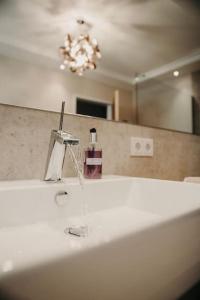 Un lavabo de baño con grifo y espejo. en Apart Veronika Imst - Exklusiv Wohnen in Imst, en Imst 16 fotos más