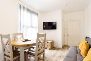 a living room with a table and a couch at Caerau Gardens in Newport