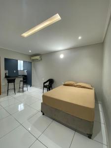 una camera con letto, tavolo e sedie di Apartamento Espanha a Ciudad del Este