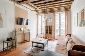 - un salon avec un canapé et une table dans l'établissement Le Clos St Louis, à Paris
