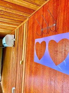 two hearts on the side of a wooden wall at Hostel Praia de Moçambique in Florianópolis