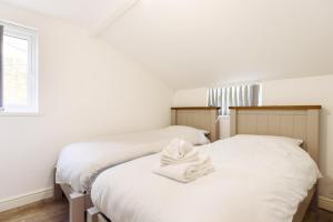 2 Betten mit weißen Handtüchern in einem Schlafzimmer in der Unterkunft Caerau Gardens in Newport