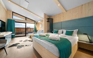 a bedroom with a large bed and a large window at Aparthotel Zell am See (Contactless Check-In) in Zell am See