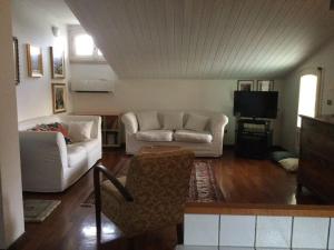 een woonkamer met twee witte banken en een televisie bij Appartamento in Villa Graziella-Napoleone - Cosy stay in San Donà di Piave