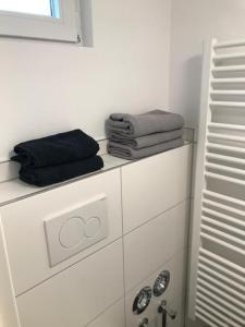 ein Bad mit Handtüchern auf der Kommode in der Unterkunft Sahra 1Zi. Wohnung Arheiligen in Darmstadt