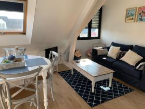 a living room with a table and a couch at TOUT A PIED ! T2 25m2 - Parking privé - Wifi in Larmor-Plage