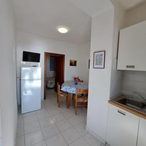 a kitchen with a table and a white refrigerator at Casa Costa e Manfredi in Chiessi +21 photos