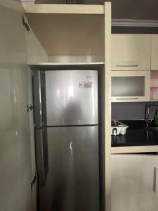a stainless steel refrigerator in a small kitchen at Water Fountain View Ancol Apartment in Jakarta