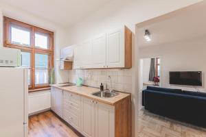 a kitchen with white cabinets and a sink at Carolina's Yoga apartment in Hradec Králové