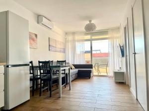uma cozinha e sala de estar com uma mesa e um sofá em Costa Daurada Apartaments - AQUARIO PINEDA em La Pineda