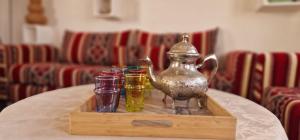 ein Tablett mit Getränken und eine Teekanne auf dem Tisch in der Unterkunft Riad Sahara Sunset Beach Agadir in Douaïra