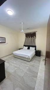 a bedroom with a bed in a room with a tile floor at نزل الخالدية in Al Qunfudhah