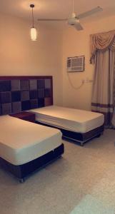 Cette chambre dispose de deux lits et de la climatisation. dans l'établissement نزل الخالدية, à Al Qunfudhah