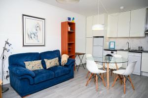 a living room with a blue couch and a glass table at Casa do Briamante 9 in Sintra