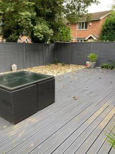 uma banheira de hidromassagem num deque com uma cerca em Hertford fabulous 2 bed garden apartment em Hertford