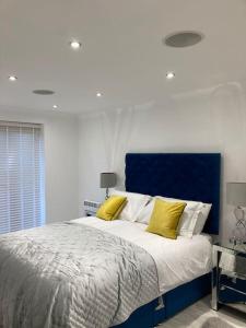 um quarto com uma cama grande e almofadas amarelas em Hertford fabulous 2 bed garden apartment em Hertford