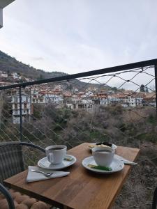 una mesa con 2 tazas de café en el balcón en THE CLIFF ALONA en Alona