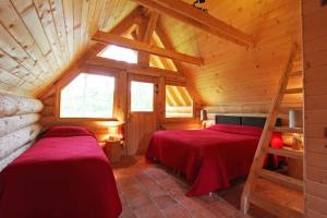 1 dormitorio con 2 camas en una cabaña de madera en Domaine de la Butte Ronde, en La Boissière-École