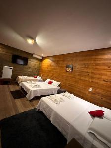 a hotel room with two beds and wooden walls at Pousada Rekantu do Poeta in Alter do Chao