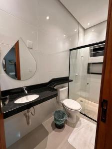 a bathroom with a toilet and a sink and a mirror at Pousada Rekantu do Poeta in Alter do Chao