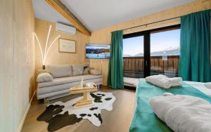 salon z kanapą, łóżkiem i oknem w obiekcie Aparthotel Zell am See (Contactless Check-In) w mieście Zell am See