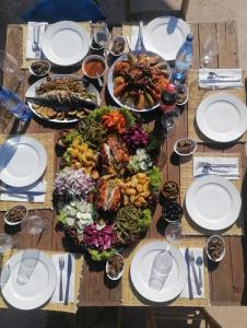 a wooden table with a bunch of food on it at Riad Sahara Sunset Beach Agadir in Douaïra