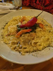 a plate of pasta with a chili pepper on it at GRS Hotéis & Reservas Salinas Resort in Salinópolis