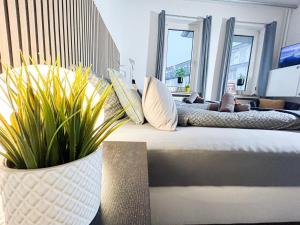 a living room with a bed with pillows and plants at Little Dream in The City in Bremen