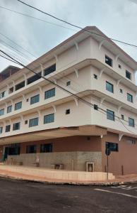 um grande edifício branco na esquina de uma rua em Hotel Darcisbel em Cacoal