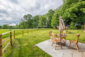 a patio with a table and chairs and an umbrella at The Gate House in Wymondham