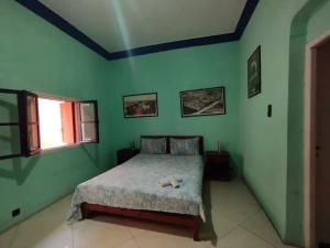 sypialnia z łóżkiem w zielonej ścianie w obiekcie Dar El jadida w mieście Al-Dżadida