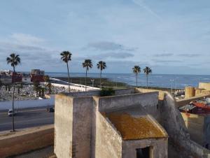 Elle offre une vue sur une ville bordée de palmiers et l'océan. dans l'établissement Dar El jadida, à El Jadida