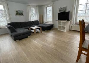 uma sala de estar com um sofá e uma televisão de ecrã plano em Gulfhof Greetsiel em Greetsiel