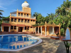 een gebouw met een zwembad en een moskee bij Le Grand Forest dreams Resort in Ukunda