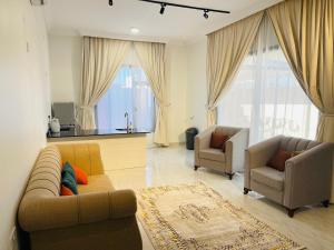 AL Rabie Resort ,Nizwa Grand Mall في Firq: غرفة معيشة مع أريكة وكرسيين