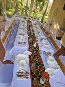 ein langer Tisch mit Teller mit Lebensmitteln drauf in der Unterkunft Le Grand Forest dreams Resort in Ukunda
