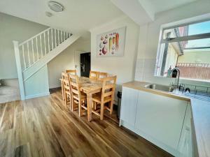 a kitchen and dining room with a table and a sink at Beautiful quiet Victorian Bungalow heart of London in London