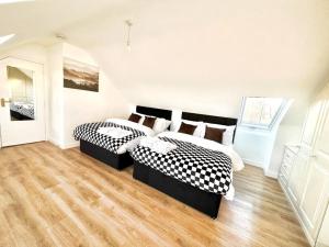 倫敦的住宿－Beautiful quiet Victorian Bungalow heart of London，白色客房的两张床,铺有木地板