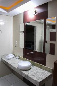 un baño con lavabo y espejo en Hotel Extasy (Adult Only), en São Vicente