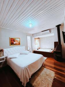 - une chambre avec un grand lit blanc et un plafond dans l'établissement Pousada Quinta dos Medeiros, à Canela